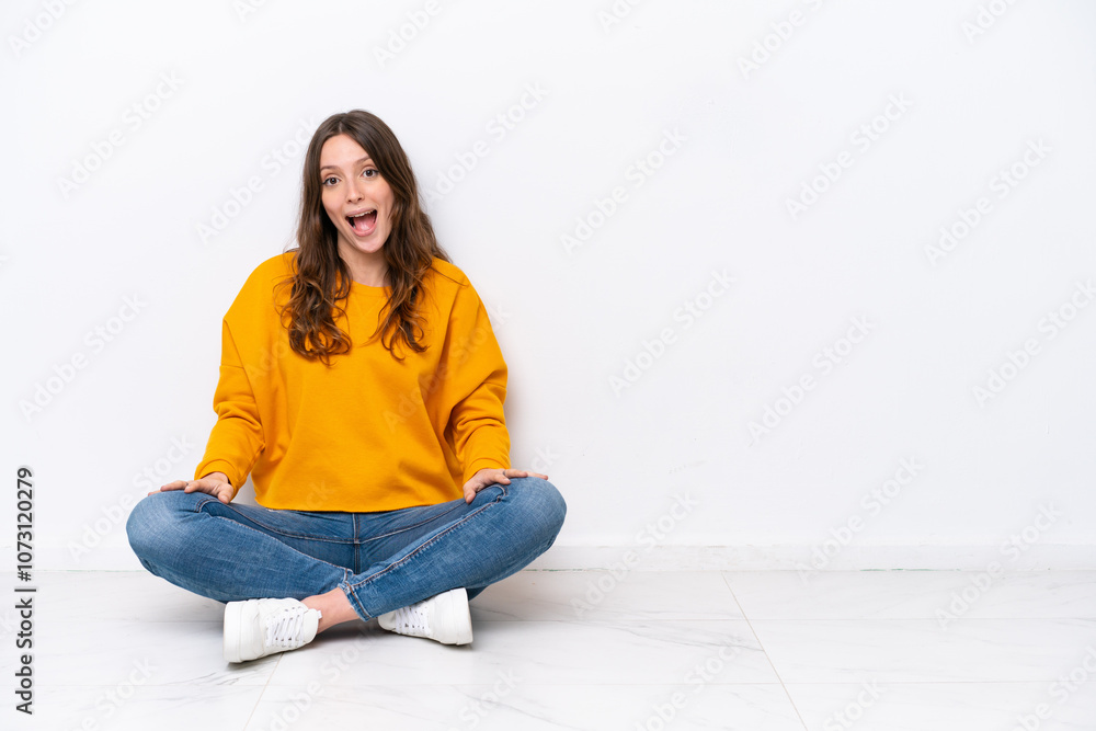 Young caucasian woman sitting on the floor isolated on white wall with surprise facial expression Young caucasian woman sitting on the floor isolated on white wall with surprise facial expression