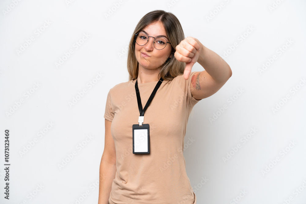 Young Rumanian woman with ID card isolated on white background showing thumb down with negative expression Young Rumanian woman with ID card isolated on white background showing thumb down with negative expression