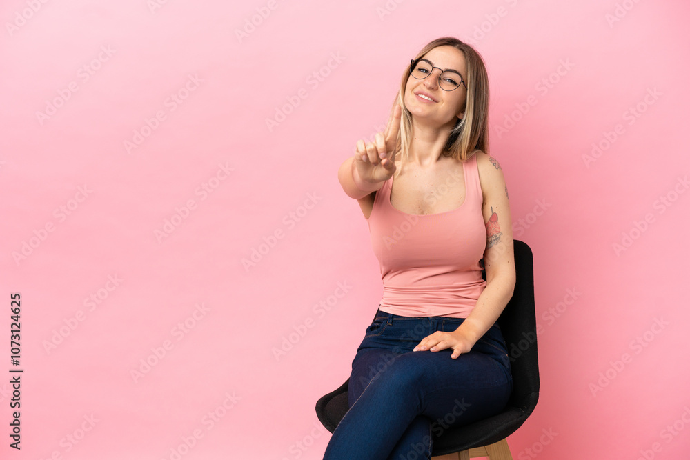 custom made wallpaper toronto digitalYoung woman sitting on a chair over isolated pink background showing and lifting a finger