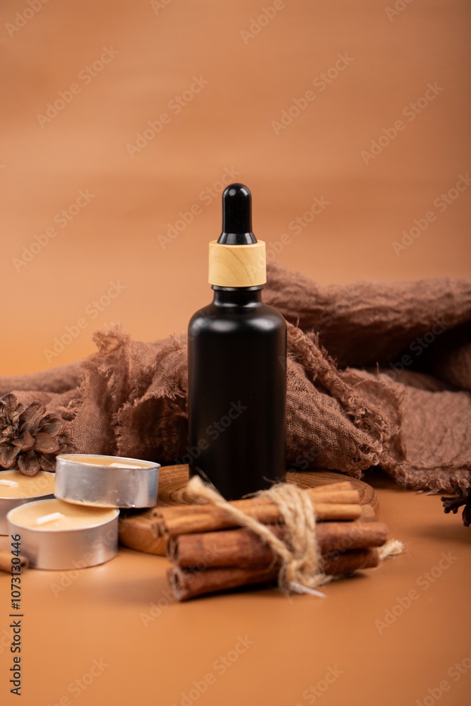 Naklejka premium Amber Glass Bottles with Cinnamon and Tealight Candles for Aromatherapy and Spa Decor