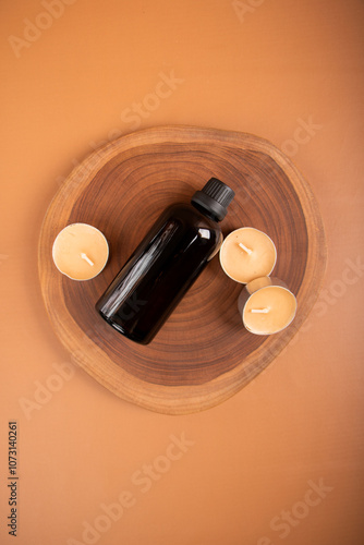 Amber Glass Bottle with Cinnamon Sticks and Tealight Candles on Wooden Tray