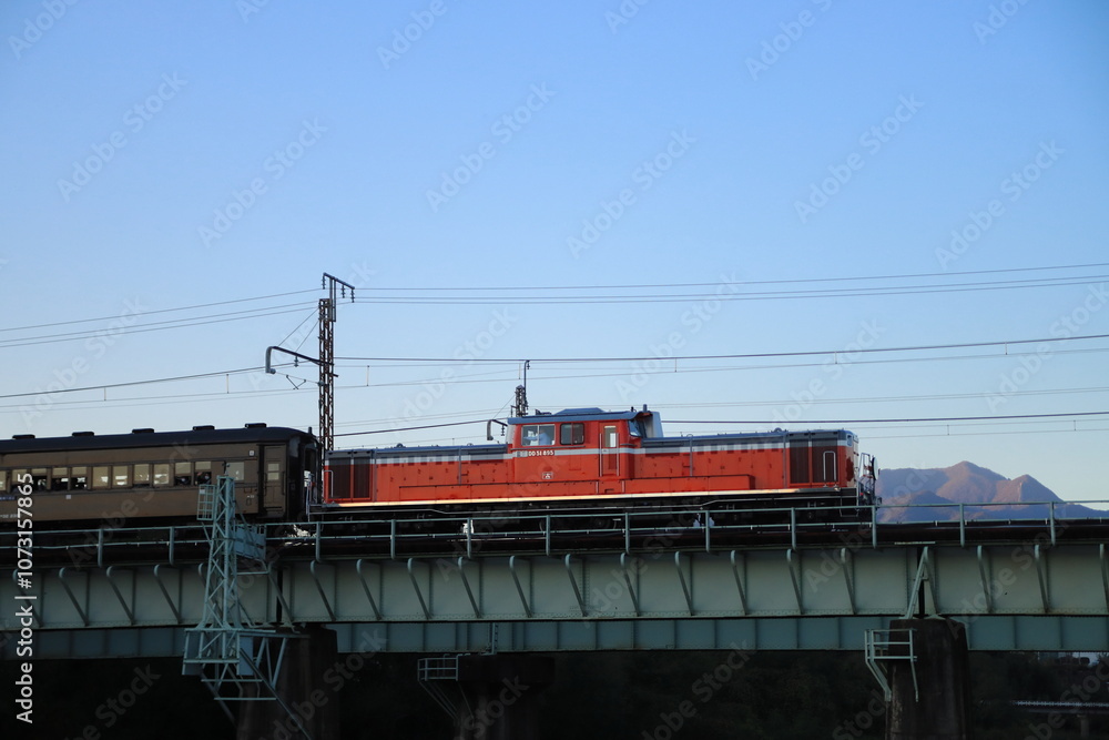 Fototapeta premium 夕暮れの残光を浴びて利根川を渡る快速ぐんまfin4号(DD51-895号機)_2024/11/9撮影