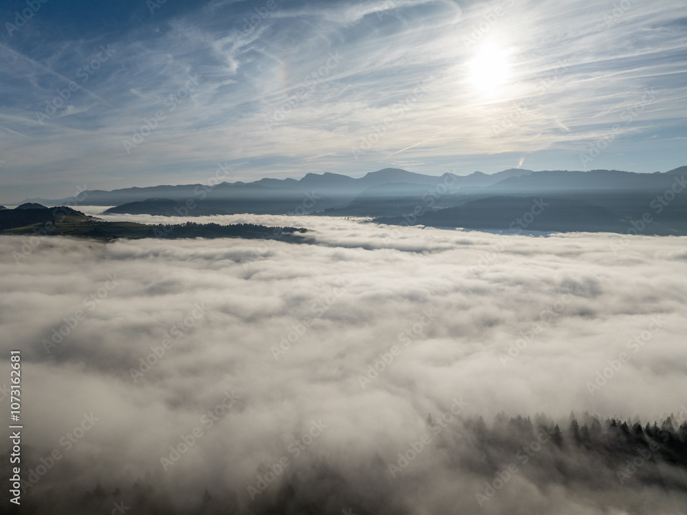 Aerial landscape photo with low level clouds on a fall morning in the border area between Germany and Austria with the Bregenz Forest Mountains, Vorarlberg, Austria , Bavaria, Germany Aerial landscape photo with low level clouds on a fall morning in the border area between Germany and Austria with the Bregenz Forest Mountains, Vorarlberg, Austria , Bavaria, Germany