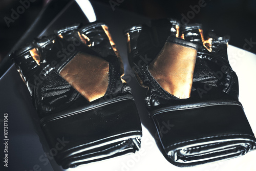 Obraz na płótnie Training boxing gloves. Black and gold boxing gloves placed on a table w salonie