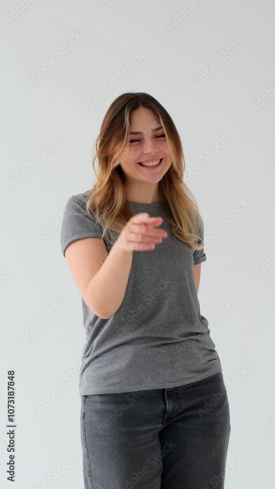 Positive woman vlogger talking to camera and engaged in interaction with audience on white background. Social media activities concept. Vertical video. Positive woman vlogger talking to camera and engaged in interaction with audience on white background. Social media activities concept. Vertical video.