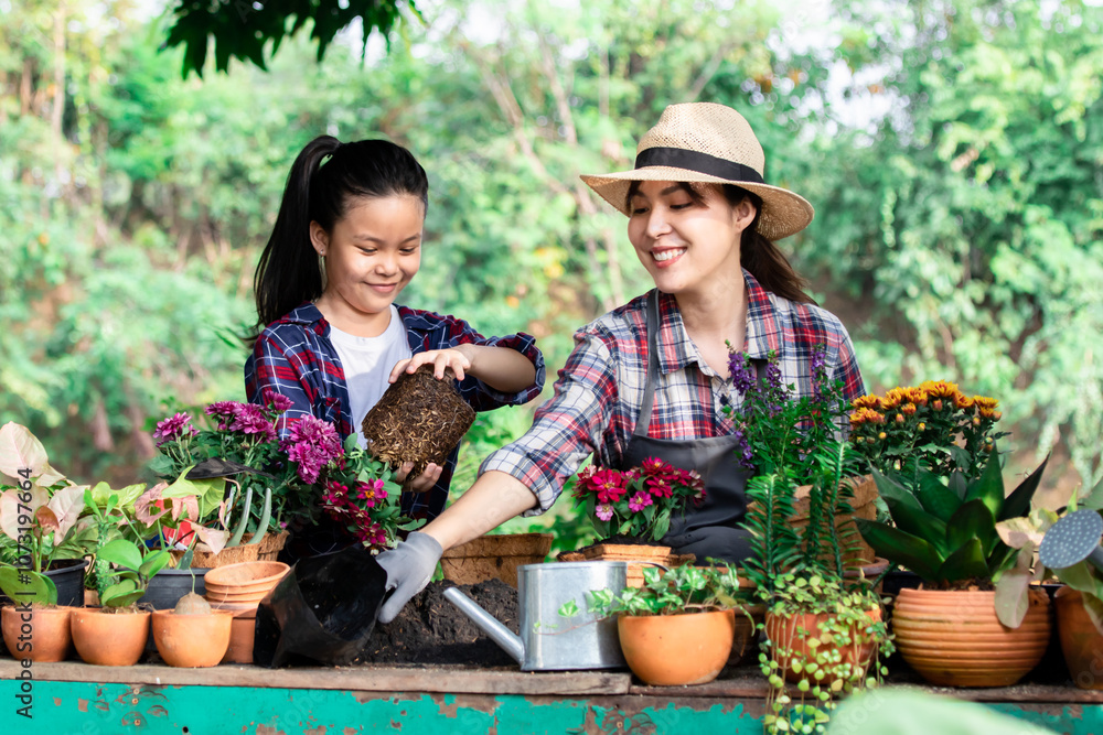 Asian woman and young girl in plaid shirts gardening together. mother teaching daughter to work with potted plants, a cheerful and nurturing environment. Outdoor activity bonding and love for nature Asian woman and young girl in plaid shirts gardening together. mother teaching daughter to work with potted plants, a cheerful and nurturing environment. Outdoor activity bonding and love for nature
