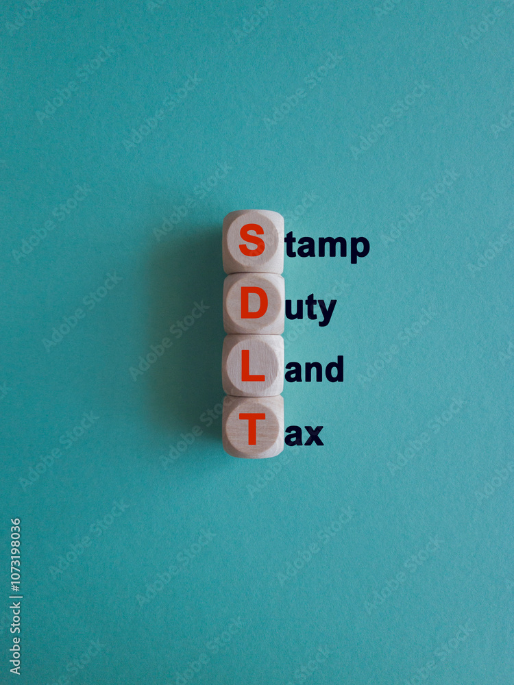 Wooden cubes with the word SDLT- Stamp duty Land Tax. Beautiful blue background. Business and buying housing and land concept.