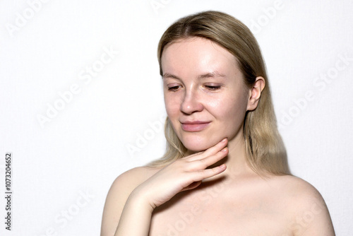 Portrait of a fair girl, without makeup and bare shoulders on a white background. 