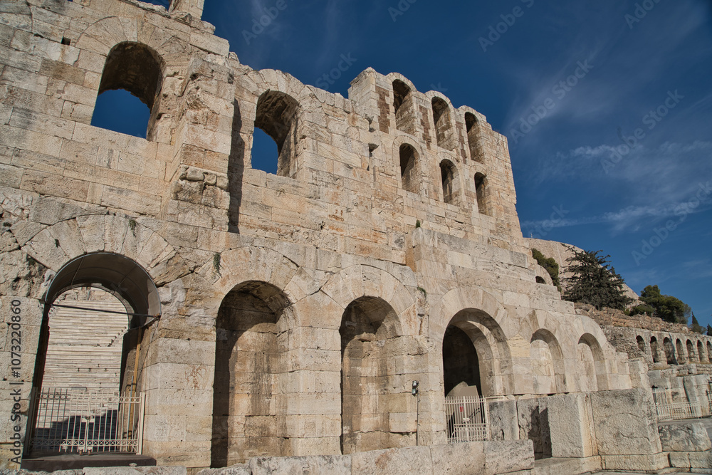 Ancient ruins of the Odeon of Herodes Atticus under a clear blue sky in Athens, showcasing its historic architecture and stone craftsmanship Ancient ruins of the Odeon of Herodes Atticus under a clear blue sky in Athens, showcasing its historic architecture and stone craftsmanship