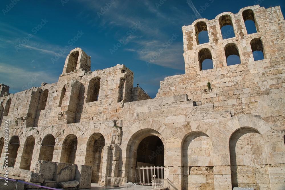 Ancient ruins of the Odeon of Herodes Atticus under a clear blue sky in Athens, showcasing its historic architecture and stone craftsmanship Ancient ruins of the Odeon of Herodes Atticus under a clear blue sky in Athens, showcasing its historic architecture and stone craftsmanship