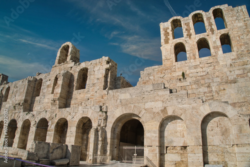 Ancient ruins of the Odeon of Herodes Atticus under a clear blue sky in Athens, showcasing its historic architecture and stone craftsmanship photo