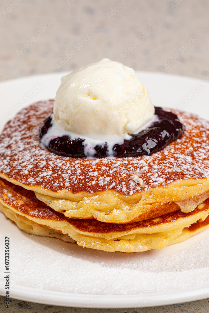 Portion of appetizing sweet pancakes with blueberries and ice cream Portion of appetizing sweet pancakes with blueberries and ice cream