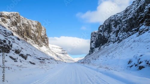 A snowy mountain pass, with clear skies overhead and snow-covered cliffs on either side