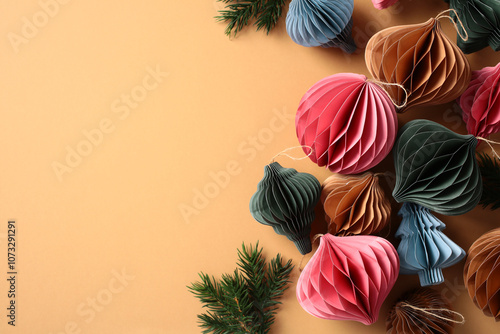 Elegant Scandinavian style Christmas honeycomb craft paper ornaments with fir branches on beige background. Flat lay, top view photo