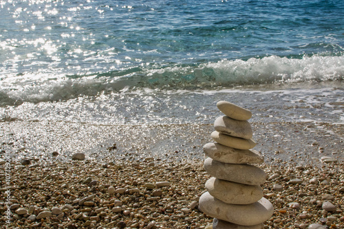 A tower of pebbles on the beach with the sea in the background, filikuri beach, albania, himare