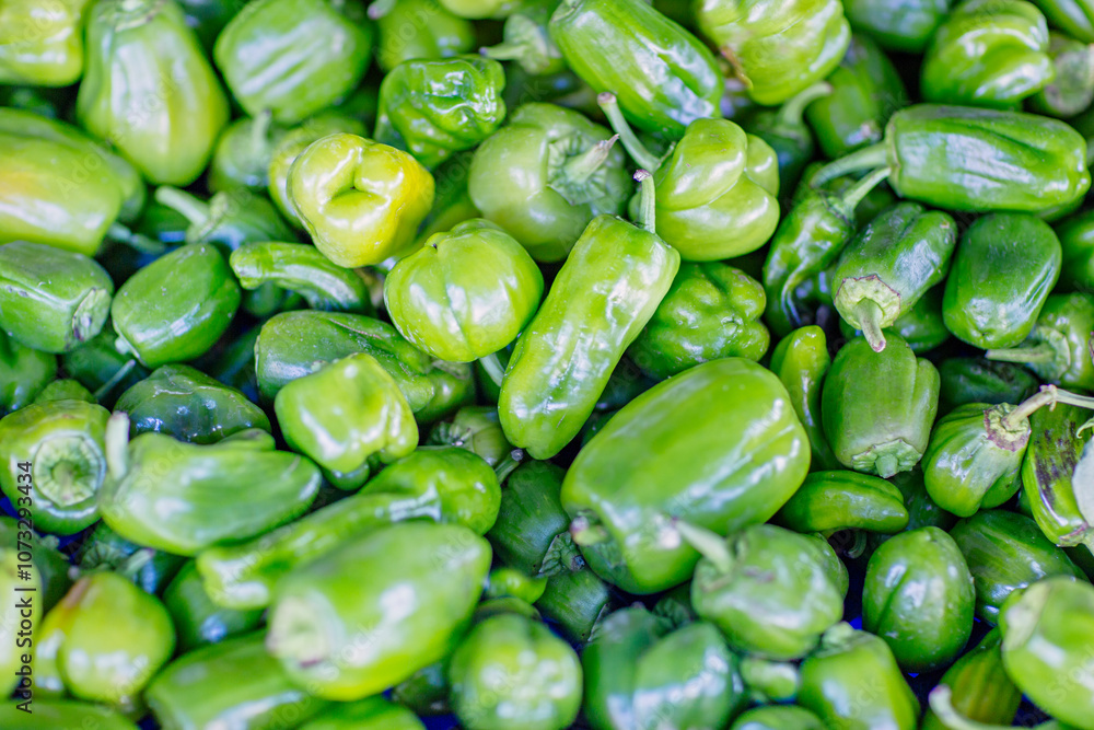 Green peppers background on the counter of a farmers market. Selective focus top view Green peppers background on the counter of a farmers market. Selective focus top view
