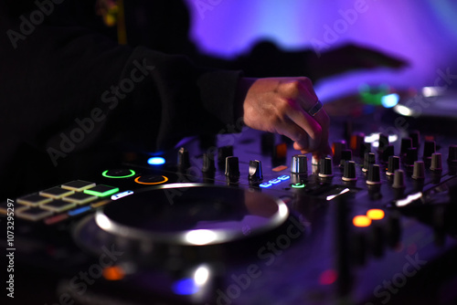 Obraz na plátně A DJ adjust audio mixing knobs on a vibrant console to creating an electric fun sound atmosphere