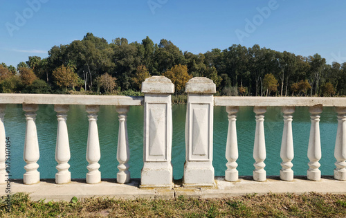 Classical styled white cement railing  along the river abnk in a city park photo