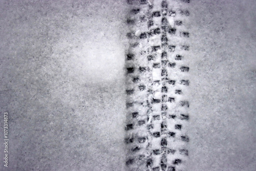 Detailed bicycle tire tread mark on fresh snow. Bike track pattern, texture left  in a winter environment. Monochrome tire print on snow, providing a contrast of black against white. Copy space
 photo