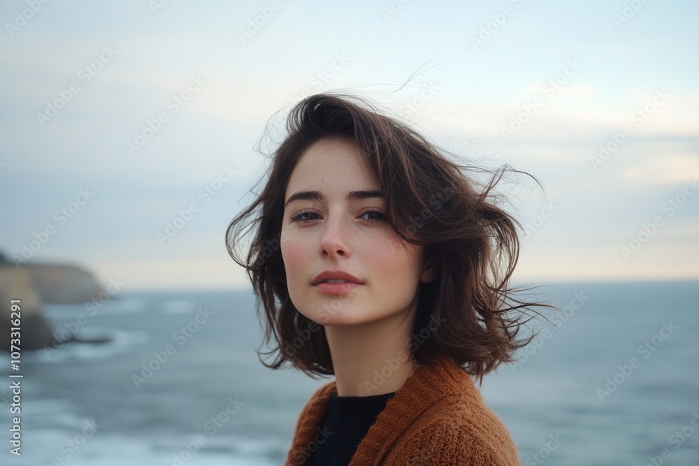 A serene moment capturing a 35 year old woman beside the ocean during dawn. The soft light illuminates her face as the wind gently blows through her hair, creating a peaceful atmosphere against a mini A serene moment capturing a 35 year old woman beside the ocean during dawn. The soft light illuminates her face as the wind gently blows through her hair, creating a peaceful atmosphere against a mini
