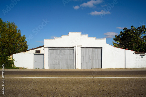 Puerta de tablones grises en nave industrial blanca