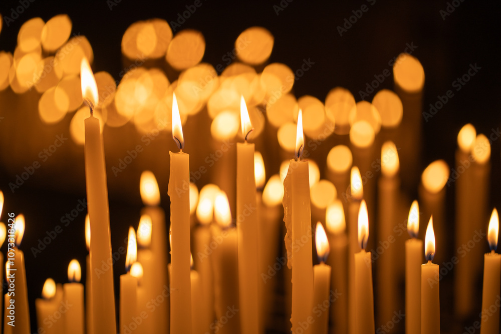 Lit candles arranged in a temple, surrounded by shadows, creating a tranquil and sacred atmosphere. The soft, flickering light contrasts beautifully with the darkness of the surroundings. Lit candles arranged in a temple, surrounded by shadows, creating a tranquil and sacred atmosphere. The soft, flickering light contrasts beautifully with the darkness of the surroundings.