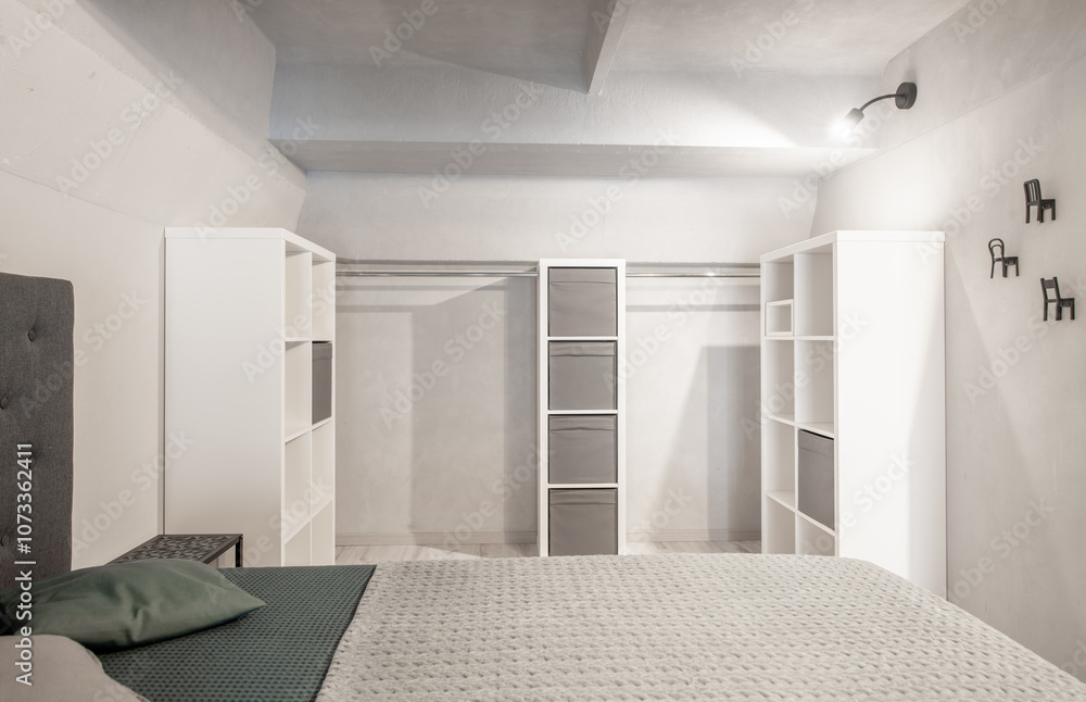 Wide Angle of Loft Home Bedroom Interiom. King Size Double Bed. White Walls. Family Home. Shelf and Closet in Backgrond Wide Angle of Loft Home Bedroom Interiom. King Size Double Bed. White Walls. Family Home. Shelf and Closet in Backgrond