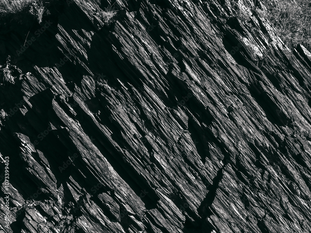 Beautiful dark grey surface stone texture background, black and white style. The strong cliff rock, cracked pattern. The jagged surface of the large rocks backgrounds. Beautiful dark grey surface stone texture background, black and white style. The strong cliff rock, cracked pattern. The jagged surface of the large rocks backgrounds.
