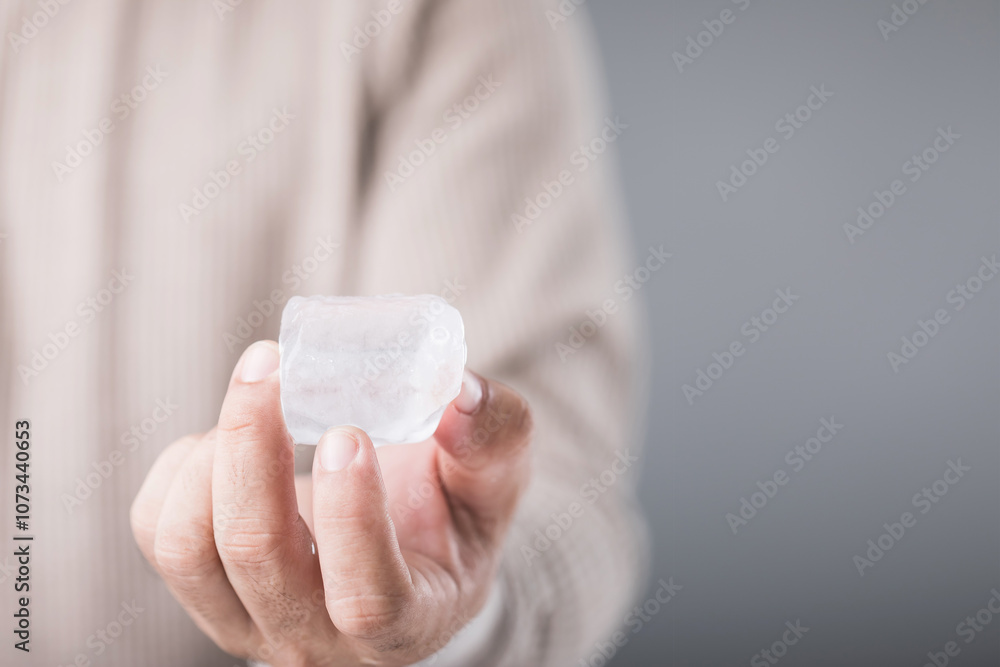custom made wallpaper toronto digitalMan holding an ice cube, with a look of discomfort due to the cold, highlighting the sensitivity and potential tooth pain from consuming cold foods. Emphasizing oral health and dental care