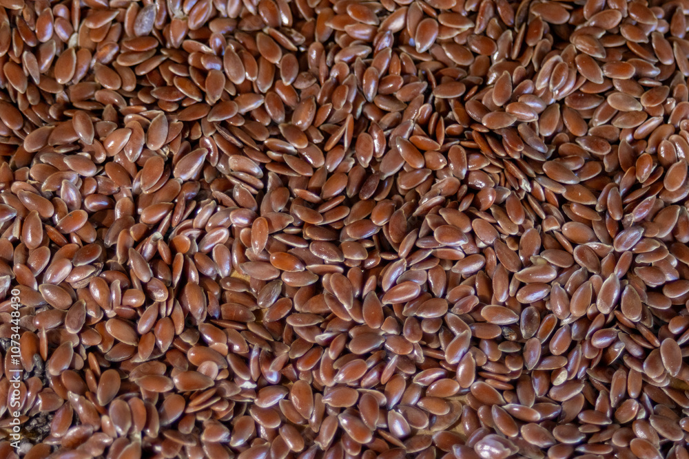 Pile of brown flax seeds scattered for background of healthy seeds promotion. Pile of brown flax seeds scattered for background of healthy seeds promotion.