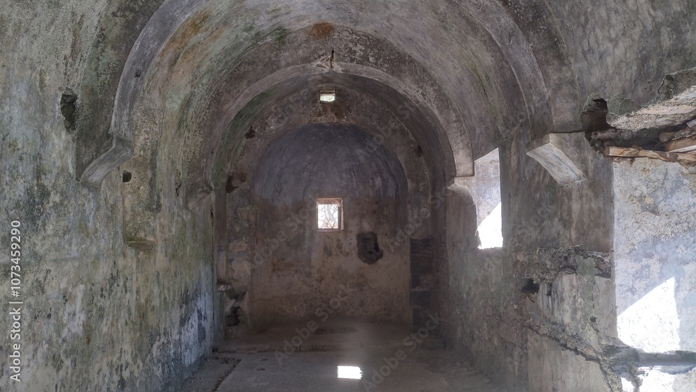 The medieval stone defensive building with arched vaults and remnants of interior plaster stands on a hill. On an autumn day, the sun streams through the small windows The medieval stone defensive building with arched vaults and remnants of interior plaster stands on a hill. On an autumn day, the sun streams through the small windows