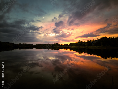 Sonnenunterng am See mit dramatischen Himmel 