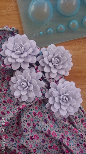 Delicate handmade felt flowers add a touch of elegance to fabric.  photo