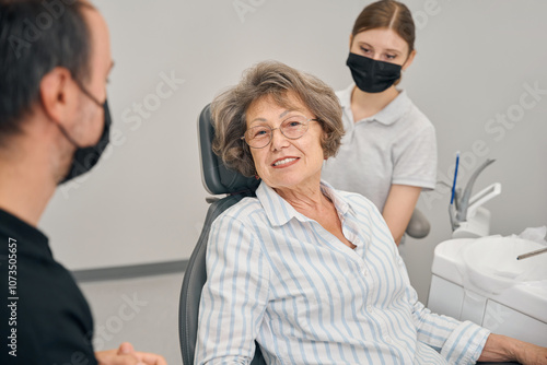 Elderly female patient at a doctors appointment communicates with specialist