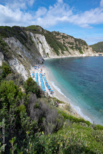 Vertical view of Sansone beach at the Elba island in summer, with sunbeds and sun umbrellas with many bathers at the seashore in relax