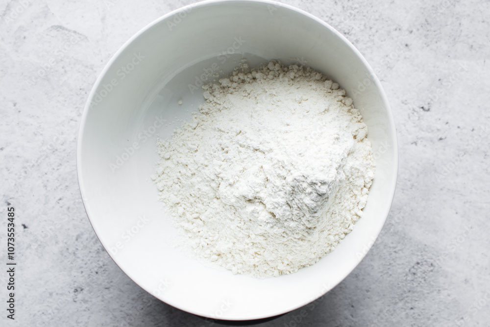 overhead view of All purpose flour in a bowl, top view of baking flour in a ceramic bowl overhead view of All purpose flour in a bowl, top view of baking flour in a ceramic bowl