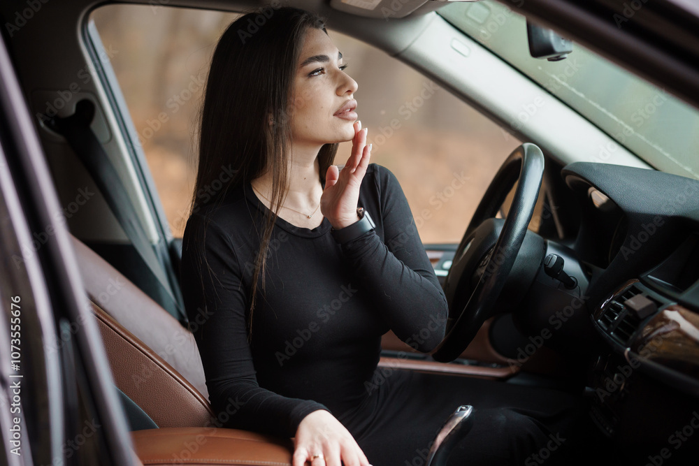 Woman in a Black Dress Sitting in a Car with a Thoughtful Expression Woman in a Black Dress Sitting in a Car with a Thoughtful Expression