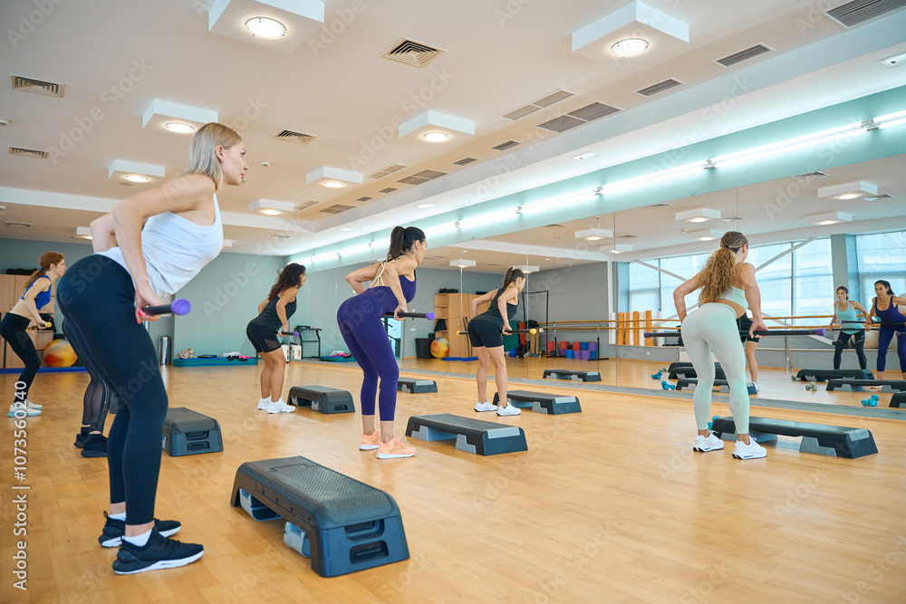 Womens health group for a lesson with sticks on platforms Womens health group for a lesson with sticks on platforms