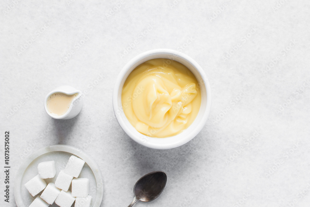 Overhead view of nigerian akamu in a white bowl with sugar and milk, pap akamu or ogi in a white bowl Overhead view of nigerian akamu in a white bowl with sugar and milk, pap akamu or ogi in a white bowl