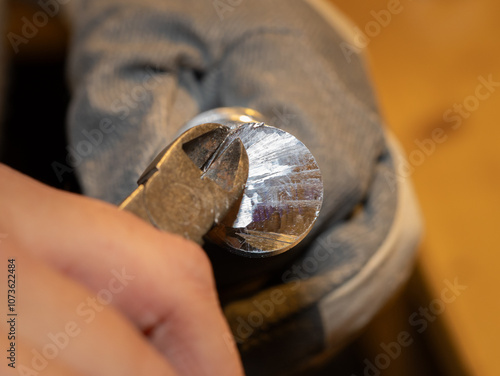Obraz na płótnie Cutting a burr of a solid aluminum part with a side cutter