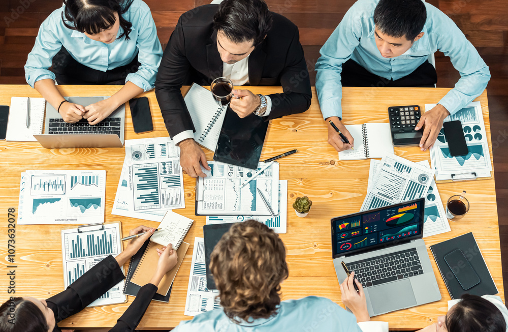 Panorama top view diverse group of business analyst team analyzing financial data report paper on meeting table. Chart and graph dashboard by business intelligence analysis. Meticulous Panorama top view diverse group of business analyst team analyzing financial data report paper on meeting table. Chart and graph dashboard by business intelligence analysis. Meticulous
