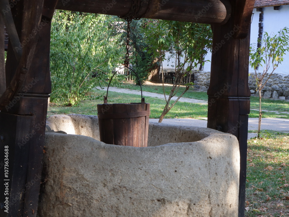 Fototapeta premium old well and wooden bucket