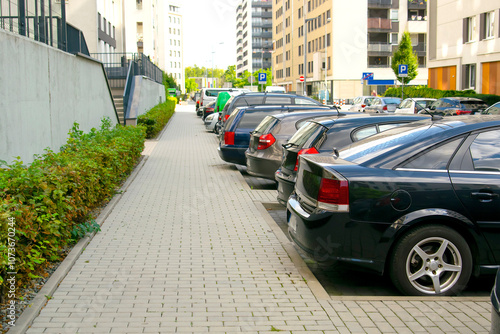 Long row of modern cars parking tightly along city road street. Urban transportation infrastructure,parking problems in residential district,technology.vehicles parked by curb. photo