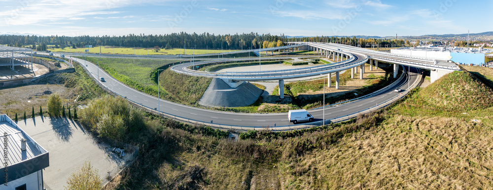 Nowy Trag, Poland. End of new Zakopinaka Highway under construction but opened for traffic. Exit rams to old road to Zakopane and Nowy Targ center. Aerial wide drone panorama. State in October 2024