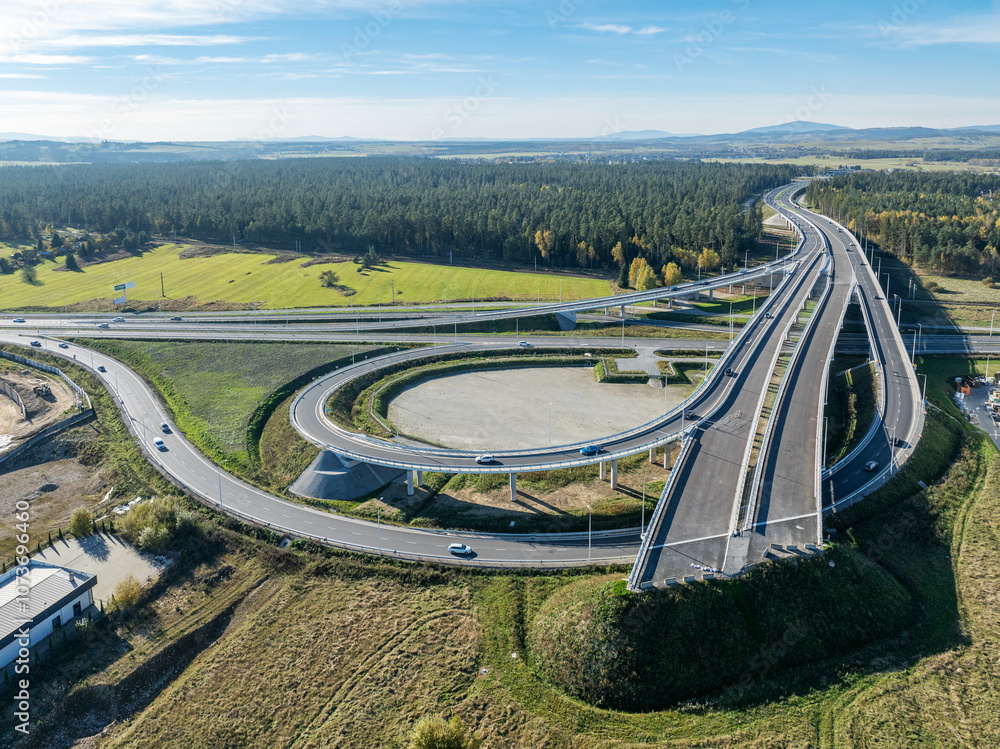 Nowy Trag, Poland. Present end of new Zakopinaka Highway under construction but opened for traffic with exit rams to old road to Zakopane and Nowy Targ town center. Aerial view. State in October 2024