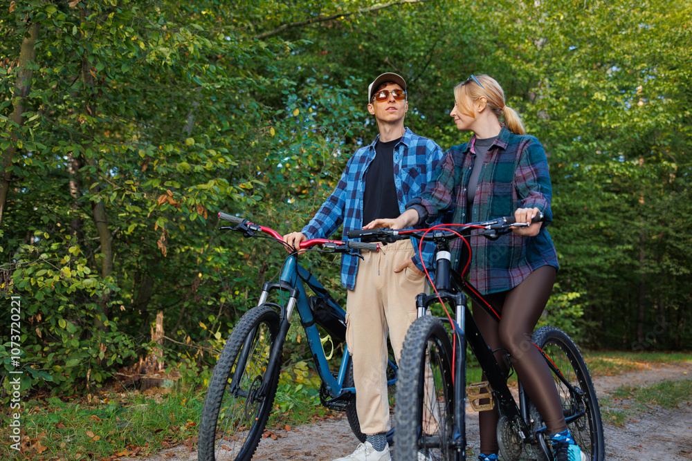 Naklejka premium A young man and a woman during a bike ride in nature