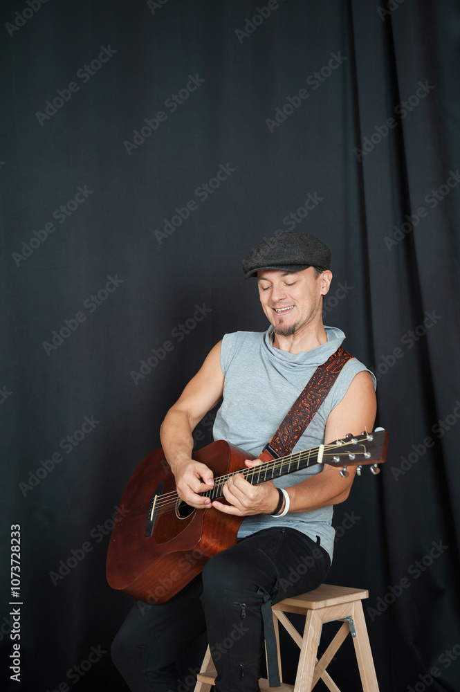 Obraz premium Musician playing an acoustic guitar in a casual studio