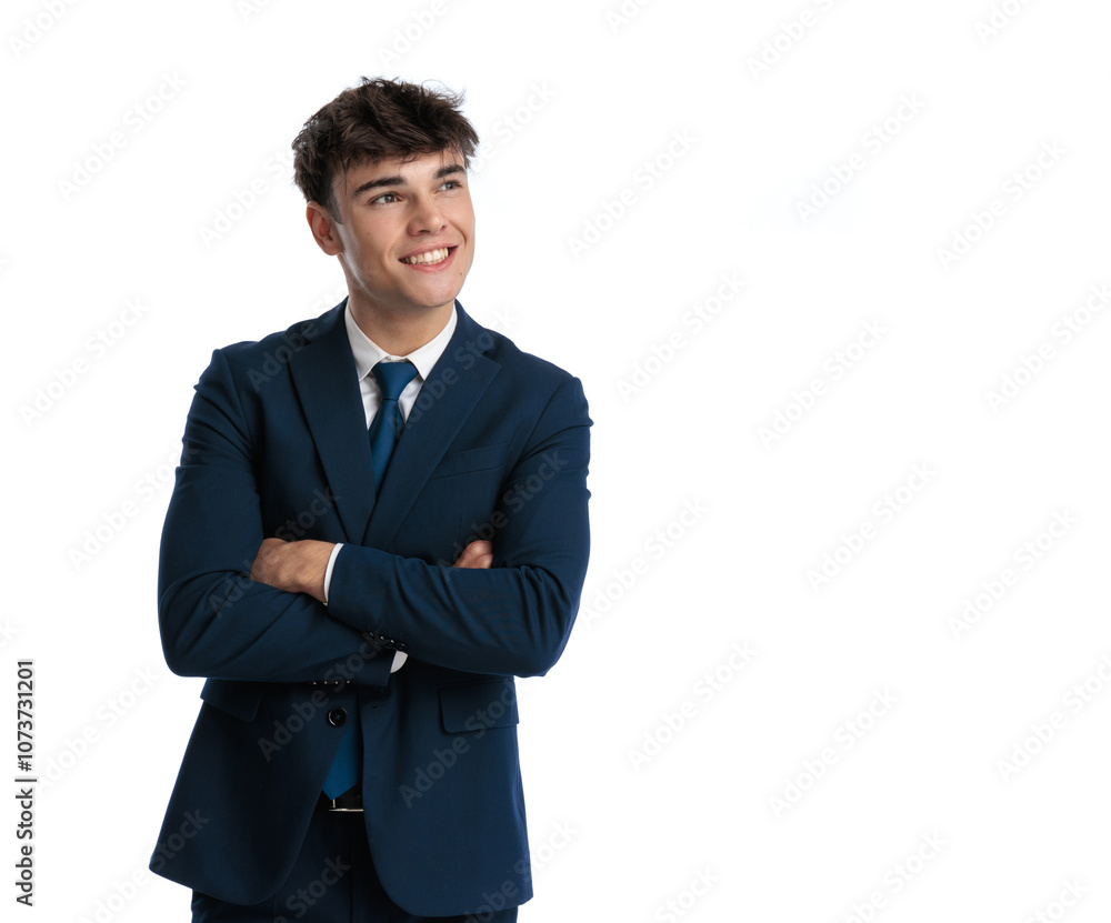 proud young businessman crossing arms, looking up and smiling proud young businessman crossing arms, looking up and smiling