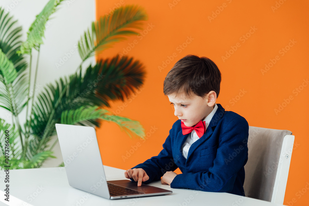 Little boy in business suit sitting at laptop Little boy in business suit sitting at laptop