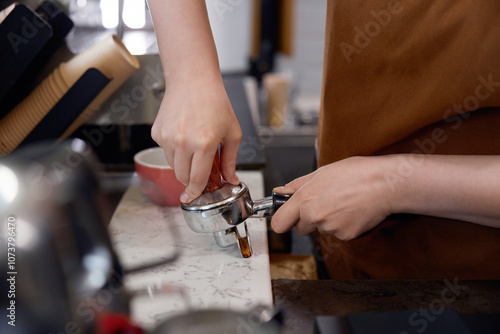 Cropped shot of woman barista making coffee, closeup view on hands